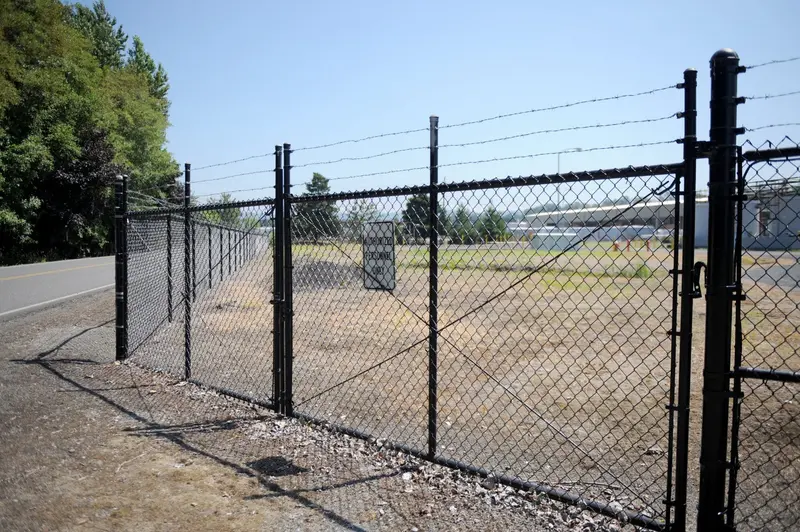 Commercial chain link security gate with barbed wire on a perimeter fence