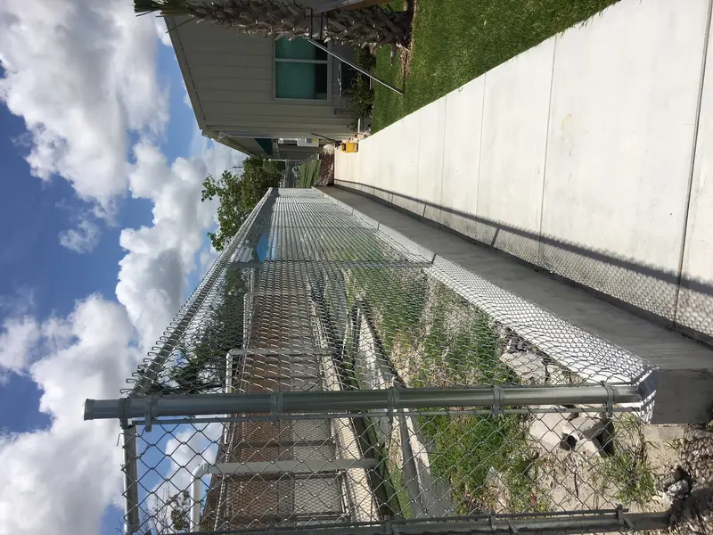 Galvanized chain link fence installation along a commercial property boundary