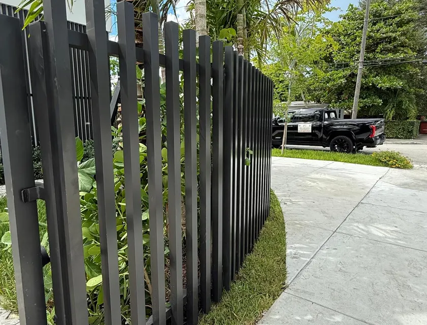 Modern vertical blade aluminum fence with heavy square profiles in matte black, custom blade spacing for South Florida privacy