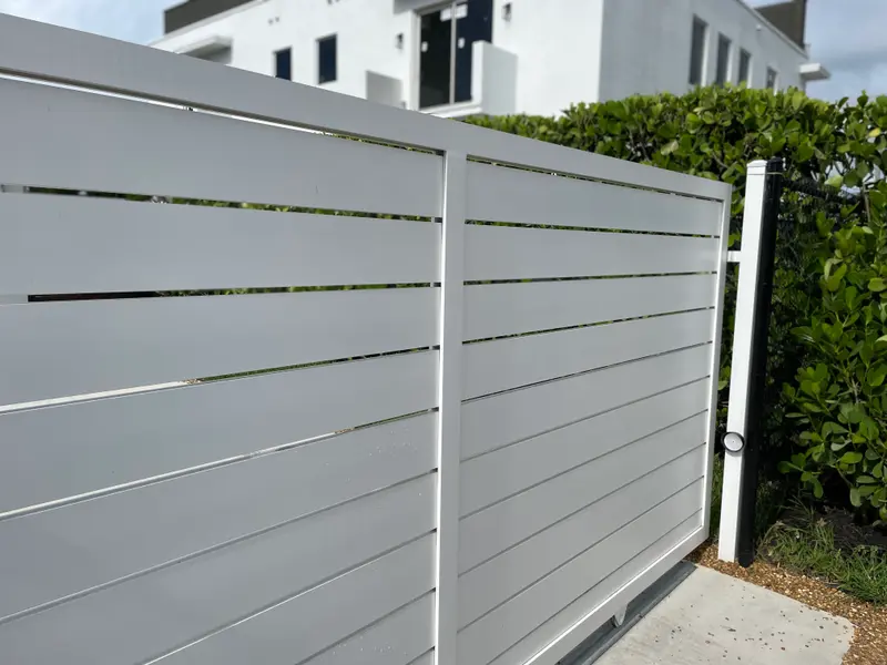 White aluminum horizontal-slat semi-privacy fence at a modern South Florida home
