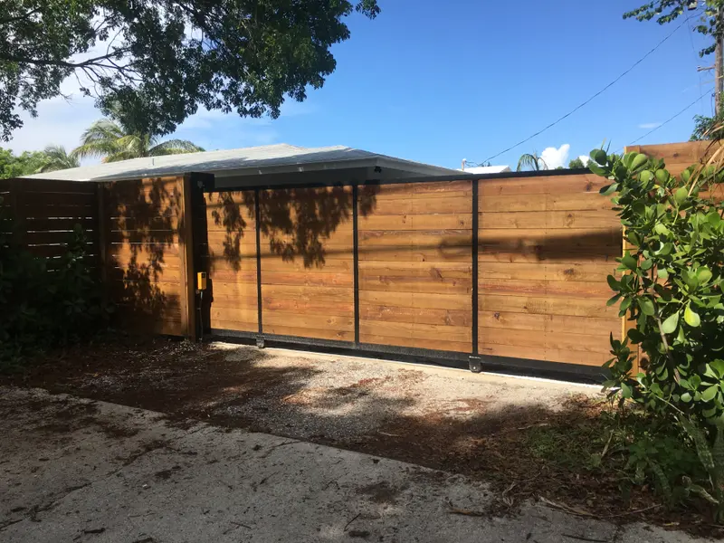 Custom horizontal wood-infill driveway gate on an aluminum frame, South Florida